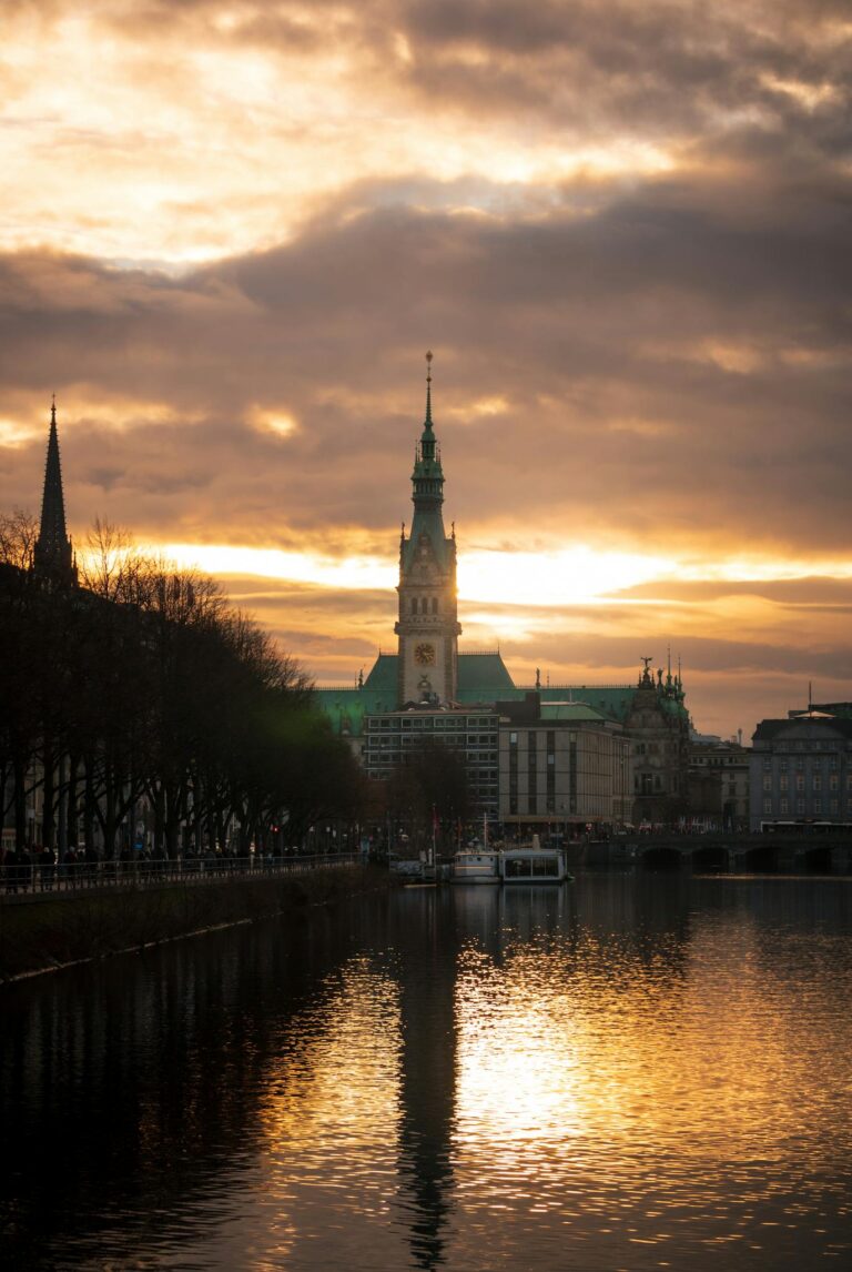 Dramatic sunset over Hamburg's Rathaus, reflecting on the River Alster.