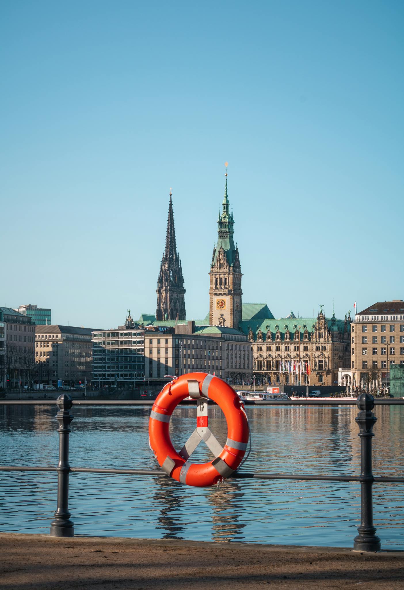 View of Hamburg's cityscape with a lifebuoy foreground, showcasing Elbe River and historic architecture.